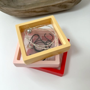 Stack of yellow, pink and red PE film jewelry boxes with necklace and heart pendant
