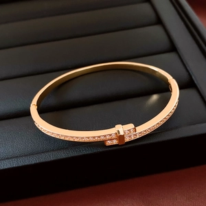 Macro shot of 18K gold plated bangle featuring a cross T design with cubic zirconia