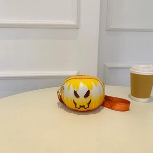 Detail of pumpkin-shaped crossbody bag with drip effect and orange graphic strap