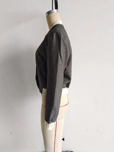 Detail view of the gray zip-up jacket with contrast white ribbed cuffs and stand collar