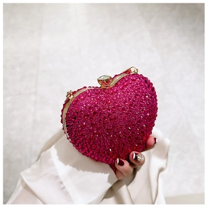Detailed close-up of heart-shaped evening bag with deep red rhinestones and gold frame