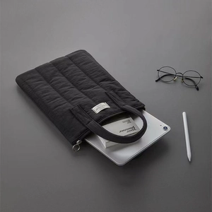 Quilted black laptop sleeve with top handle for 13-inch tablet, minimalist business style