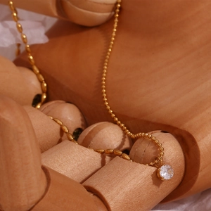 Dettaglio collana a sfere placcata oro 18K con pendente tondo in zircone brillante
