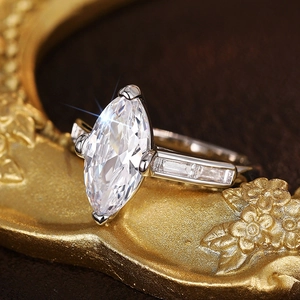 Macro detail of marquise-cut diamond ring with baguette side stones on vintage gold prop