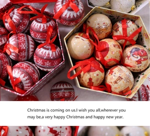 Close-up of red and beige Christmas balls with ribbons in a hexagonal gift box