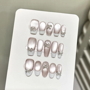 Pink cat eye press-on nails with white French tips and silver 3D ribbon bows