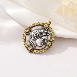 Close-up of vintage Greek relief pendant with silver portrait and gold crystal border