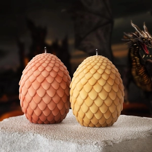 Detalle de velas de huevo de dragón con textura de escamas sobre superficie de piedra