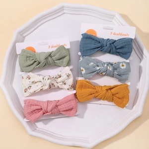 Detailed set of six floral and solid cotton bow baby headbands in various colors on a tray