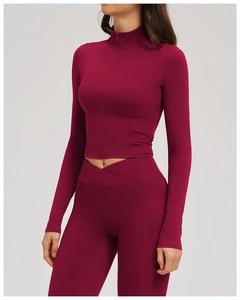 Detail of burgundy yoga set featuring cross waist leggings and zippered jacket