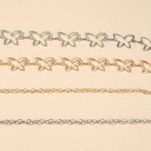 Detailed view of hollow butterfly charms and simple gold and silver metal alloy chains