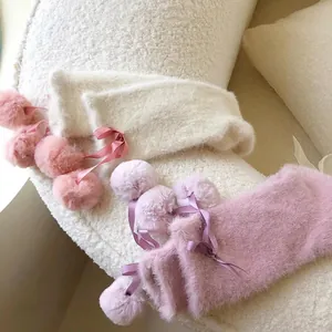 Japanese style plush leg warmers with satin bows and pom-poms in creamy white and pink