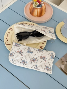 Detail of quilted cotton storage pouches with vintage cartoon prints and zipper closures
