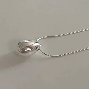 Minimalist silver water drop pendant necklace with sleek snake chain on grey background
