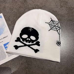 Close-up of knitted beanie with white skull, crossbones and spider web graphic patterns