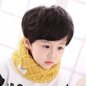 Detail of yellow chunky knit kids neck warmer with cozy woven texture and soft beige label