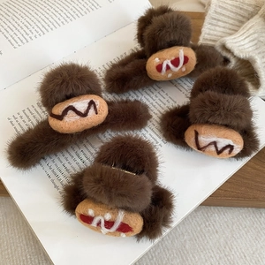 Detail of dark brown flocked bread-shaped hair claws on vintage book pages
