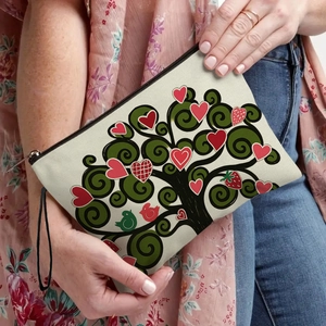 Off-white canvas makeup bag with cute cartoon tree and bird print held by hand
