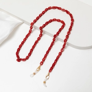 Detail of red acrylic glasses chain with gold lobster clasps and anti-slip rings