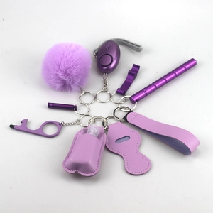 Detail of a purple safety keychain set including alarm, pompom, and window breaker tool