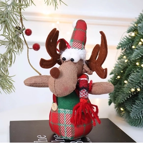 Detailed plush reindeer ornament with red hat and green scarf in a festive Christmas setting