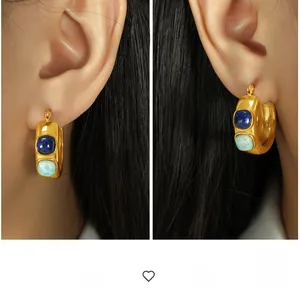 Detailed view of chunky gold-plated C-shape earrings with inlaid blue natural stones