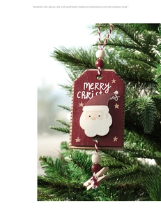Detail of wooden Santa Claus ornament hanging on a Christmas tree with festive clips