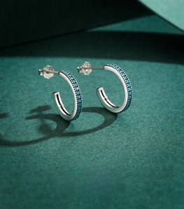 Detail of C-shaped 925 sterling silver hoop earrings with turquoise beads and beaded trim
