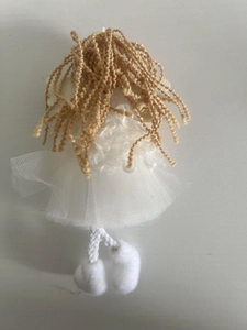Detail of white plush Christmas angel ornament with golden hair and tulle skirt