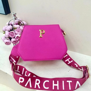 Detailed view of pink geometric tote bag with gold P emblem and branded wide strap
