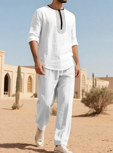 Detail of white linen beach set featuring a henley collar shirt and drawstring trousers