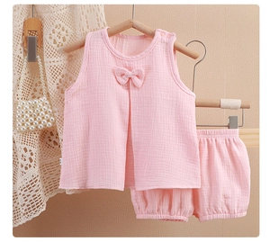 Détail d'un ensemble en gaze rose pour bébé avec haut sans manches et short assorti