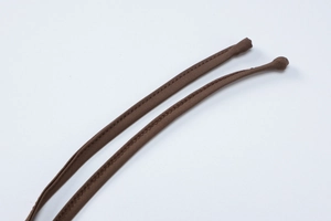 Detail view of brown slim fabric shoulder straps with professional double-stitched sewing