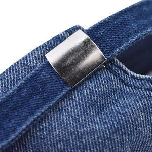 Detail of adjustable metal buckle and dark blue washed denim texture on baseball cap