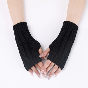 Close-up of black cable-knit fingerless gloves showing detailed wool texture and short fit