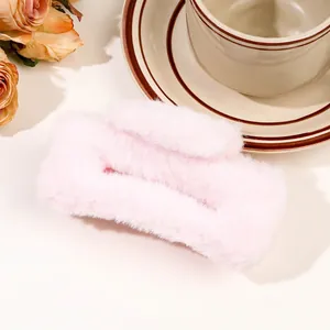 Detail of a large plush rectangular hair claw clip in soft pink faux fur texture