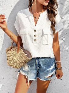 Detail of white V-neck blouse with textured Swiss dots and golden fashion accessories