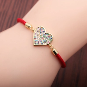 Adjustable red string bracelet with heart zircon pendant on a woman's wrist