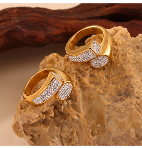 Detalle de anillo de doble capa dorado con circonitas sobre una piedra natural