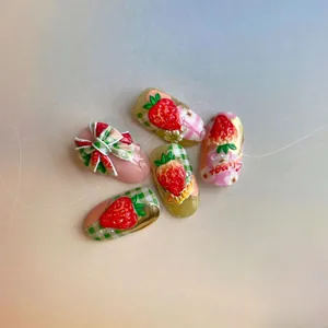 Détail macro de stickers ongles 3D fraise avec nœuds mignons et motifs de fruits