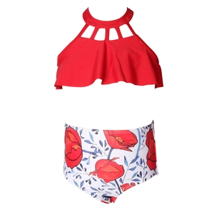 Détail d'un maillot de bain deux pièces fille avec haut licou rouge et culotte à fleurs