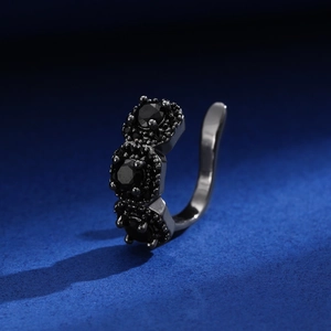 Macro detail of black metal ear cuff with three sparkling black cubic zirconia stones