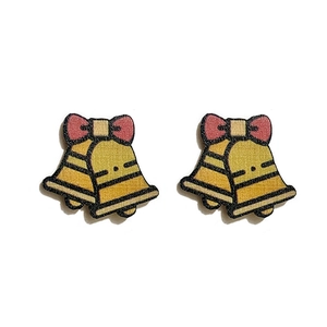 Macro detail of cartoon wooden bell earrings with a red bow tie for Christmas