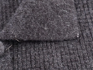 Close-up of dark grey ribbed knit fabric with soft mohair-like fluffy fibers and texture