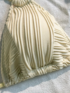 Detailed macro shot of cream-white ribbed knit swimwear fabric showing texture