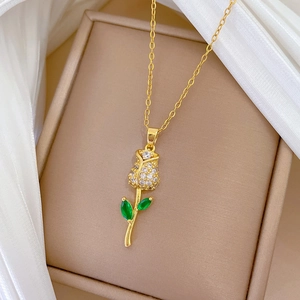 Detailed shot of gold rose pendant with sparkling crystals on white silk background