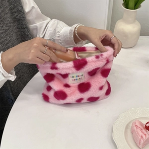 Detail showing the pink leopard plush cosmetic bag with a woven brand label