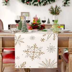Close-up of linen table runner with gold and silver snowflake prints for Christmas decor