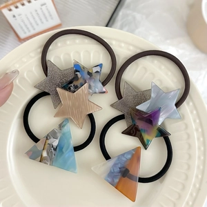 Set of 4 cute star and triangle hair ties with marble texture on a white tray