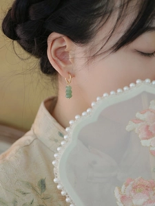 Close-up of green aventurine stone earrings with gold hoops on female model